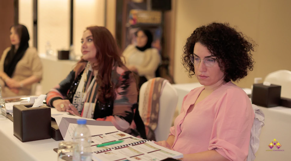 Group of diverse medical professionals attending an advanced cosmetic gynecology lecture by an expert, demonstrating techniques with modern equipment in a professional classroom setting.