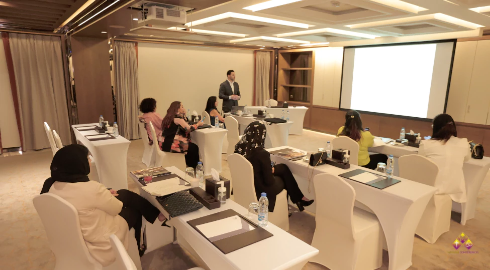 Group of diverse medical professionals attending an advanced cosmetic gynecology lecture by an expert, demonstrating techniques with modern equipment in a professional classroom setting.