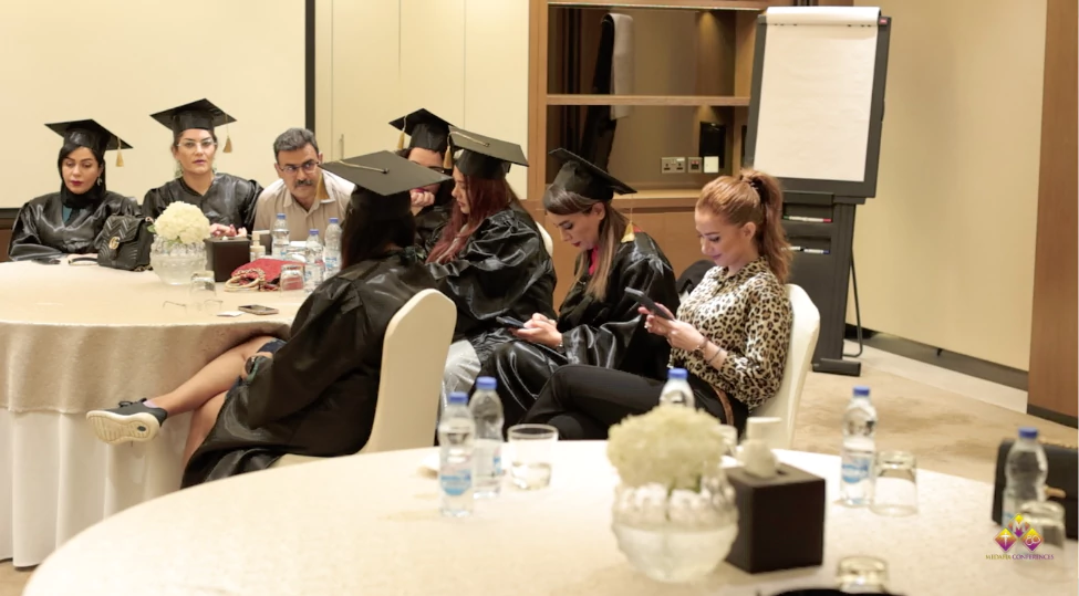 Group of diverse medical professionals graduating the board certification in cosmetic gynecology, demonstrating techniques with modern equipment in a professional classroom setting.